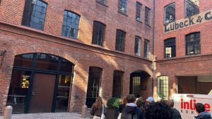 Studerende ved historisk rødstensbygning i Lübeck med fokus på kultur, arkitektur og studietur i Tyskland.
