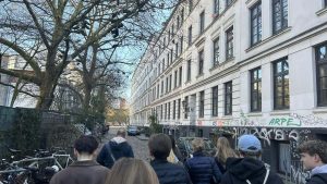 Studerende går gennem historisk gade i Hamburg med klassiske bygninger, graffiti og fokus på kultur og studietur.