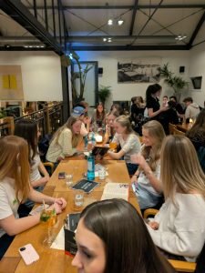 Unge studerende sidder samlet på hyggelig café og restaurant i København med fokus på socialt fællesskab og studieliv.